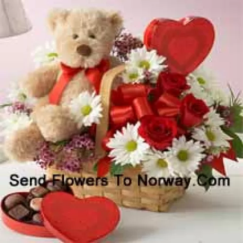 Un beau panier composé de roses rouges, de géraniums blancs et de remplissages saisonniers, une boîte de chocolat importée et un mignon ours en peluche brun