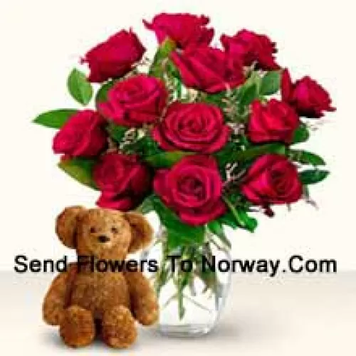 11 rote Rosen mit einigen Farnen in einer Glasvase zusammen mit einem niedlichen 12 Zoll großen braunen Teddybär