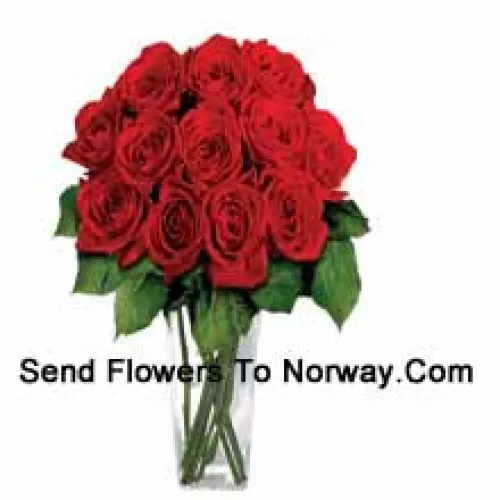 15 roses rouges avec quelques fougères dans un vase en verre