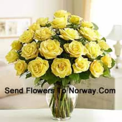 25 Roses jaunes divines avec quelques fougères dans un vase en verre