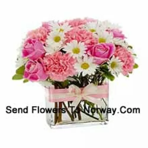 Roses roses, oeillets roses et diverses fleurs blanches de saison arrangées magnifiquement dans un vase en verre