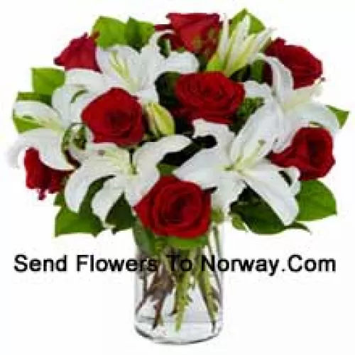 Rosas rojas y lirios blancos con rellenos de temporada en un jarrón de vidrio