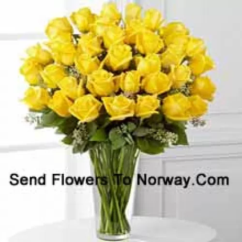 37 roses jaunes avec quelques fougères dans un vase en verre