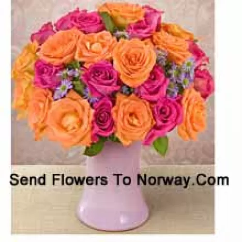 15 roses roses et 10 roses orange avec des garnitures de saison dans un vase en verre