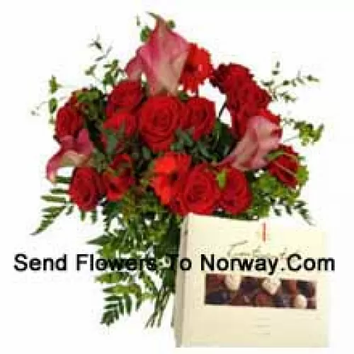 Rote Gerbera und rote Rosen in einer Vase zusammen mit einer Schachtel Schokolade
