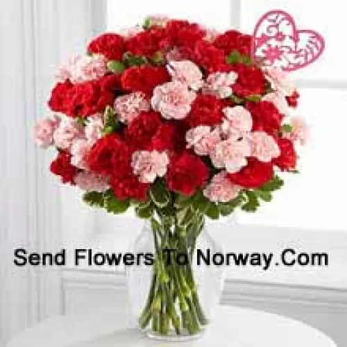 42 Carnations ( 18 Red And 18 Pink ) With Seasonal Fillers And Heart Stick In A Glass Vase